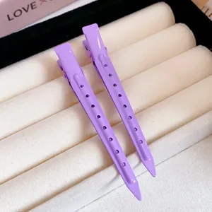 Detailed close-up showing two lavender purple duckbill hair clips on a soft display