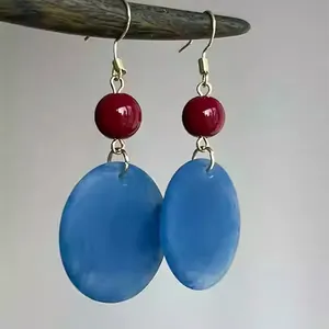 Gros plan sur des boucles d'oreilles rétro en acrylique givré avec goutte bleue