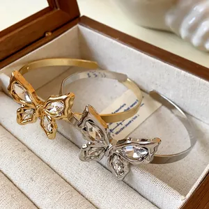 Detailed view of gold and silver butterfly open bangles with sparkling crystals.