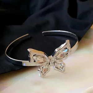 Macro view of silver open cuff bracelet featuring a crystal-studded butterfly design