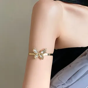 Close-up of elegant gold butterfly arm cuff with sparkling rhinestones on model's arm