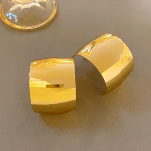 Dettaglio di orecchini a cerchio a forma di C larghi in oro con finitura a specchio