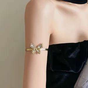 Close-up of elegant gold butterfly armlet with sparkling rhinestones on model's arm