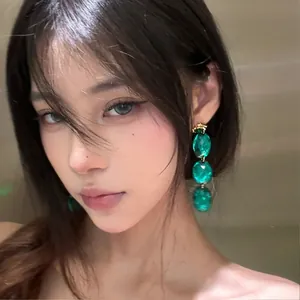 Vintage emerald green acrylic geometric rhinestone drop earrings shown on a female model
