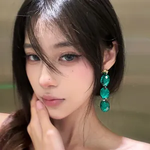 Elegant vintage emerald green acrylic geometric drop earrings worn by a beautiful model