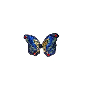 Elegant embroidered butterfly earring with blue gradient and sparkling red rhinestones