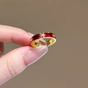 Dettaglio dell'anello d'oro con smalto rosso e fiori di zircone scintillanti