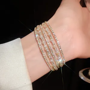 Detailed view of elegant multi-layer bracelet with pearls and rhinestones on wrist