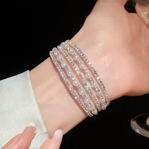 Exquisite close-up view of elegant multi-layered rhinestone and pearl bracelet on a wrist