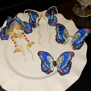 Detail view of blue embroidered butterfly earrings with sparkling crystal tassels