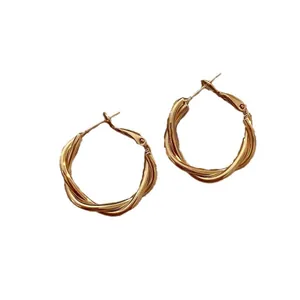 Elegant gold-tone twisted metal hoop earrings with a chic intertwined wire design