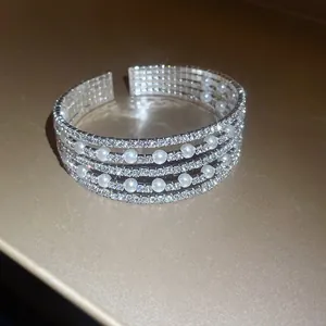 Detail view of multi-layer cuff bracelet with sparkling rhinestones and pearls