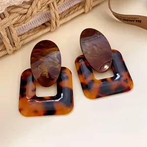 Detailed view of vintage tortoiseshell and marble resin earrings in a geometric style