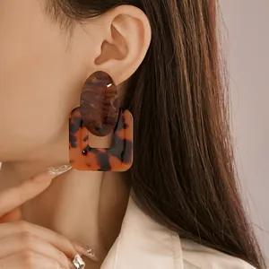 Detail shot of vintage tortoise shell resin earrings with geometric square and oval design