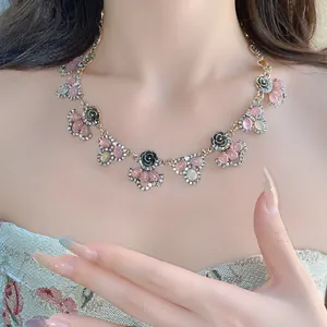 Detail view of a vintage flower necklace with pink resin stones and shiny rhinestones