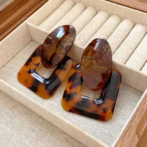 Detail view of retro leopard print resin earrings with square and oval geometric design