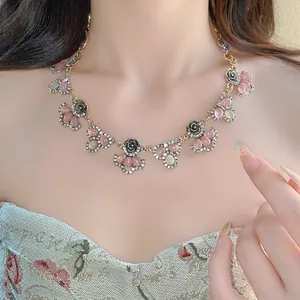 Close-up of vintage resin necklace with black rose motifs and sparkling rhinestone details