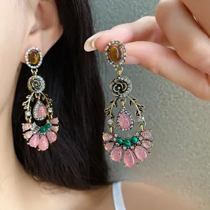 Close-up of vintage resin flower drop earrings with rhinestones and pink stones