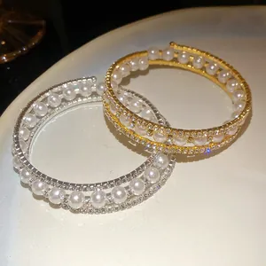 Dettaglio dei bracciali aperti a tre strati con perle e cristalli brillanti