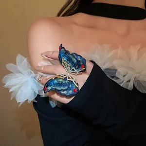 Close-up of elegant blue embroidered butterfly earrings featuring fine sparkling rhinestones