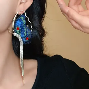 Detailed macro shot of ethnic style butterfly earring with long sparkling tassels