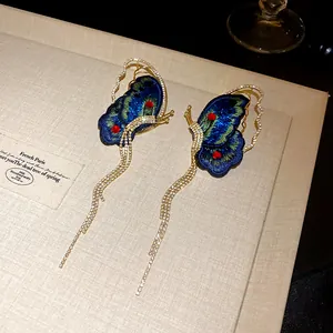 Detail view of luxury embroidery butterfly tassel earrings with crystals.