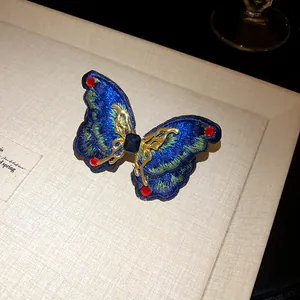 Detailed view of embroidered butterfly earring with crystal accents in ethnic style
