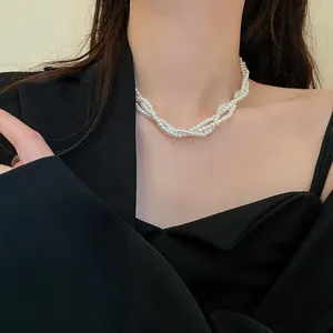 Detailed view of a multi-strand white pearl necklace worn as a stylish clavicle chain