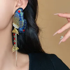 Close-up of ethnic embroidered butterfly tassel earrings with rhinestones and beads