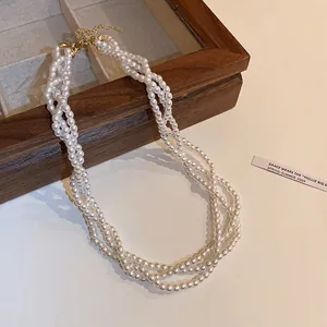 Detailed view of a baroque vintage multi-strand pearl necklace with a gold clasp.