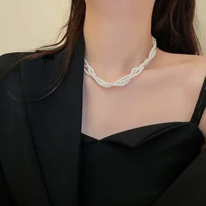 Close-up of elegant multi-strand white pearl necklace worn with a stylish black blazer.