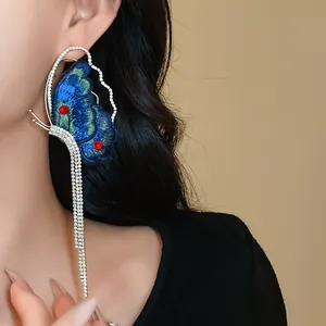 Detail view of elegant embroidered butterfly earrings with long sparkling rhinestone tassels