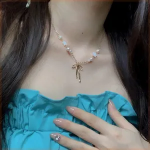Close-up detail of a French bow pearl necklace featuring star beads on model's neck