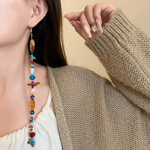 Orecchini bohémien lunghi e colorati con pietre naturali e perline di vetro.