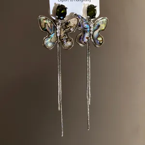Detailed view of exquisite vintage butterfly tassel earrings featuring iridescent abalone shell inlay