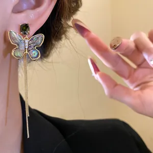 Close-up view of elegant 18K gold plated butterfly tassel earring with seashell inlay details