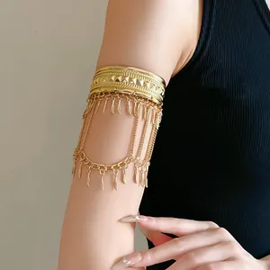 Vista dettagliata di un bracciale boho dorato con frange di piume e nappe a foglia