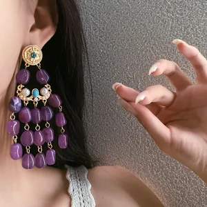 Close-up of elegant purple beaded tassel earrings on a model with vintage style.