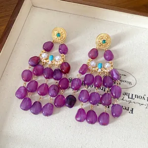 Exquisite close-up of vintage purple tassel earrings with elegant gold and pearl accents