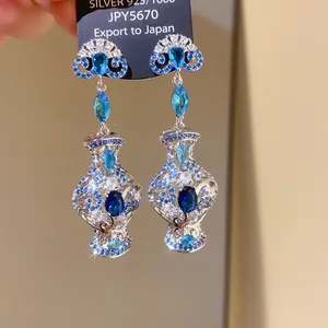Exquisite close-up of luxurious blue zircon drop earrings with detailed silver craftsmanship