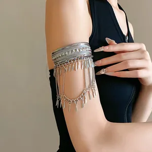 Vista dettagliata di un bracciale da braccio in argento con piume e nappe su una donna