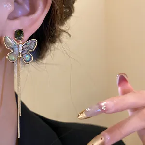 Close-up of 18K gold plated butterfly tassel earring with shell inlay and zircon