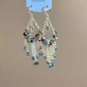 Detailansicht von böhmischen Quastenohrringen mit bunten Kristallperlen und Goldkette