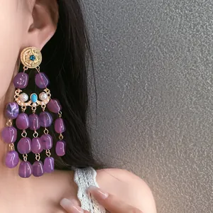 Detail view of elegant vintage-style purple beaded tassel earrings worn by a model.