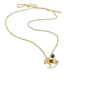 Élégant collier pendentif cheval à bascule en or avec cristaux et pierres œil de tigre.