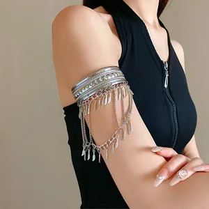 Dettaglio di un bracciale da braccio in argento con ciondoli a piuma e foglia