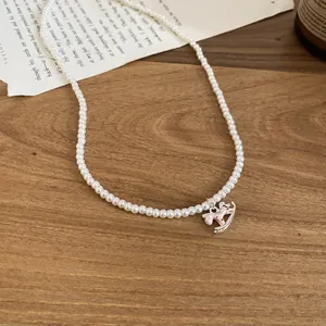Détail élégant d'un collier de perles avec pendentif cheval à bascule rose