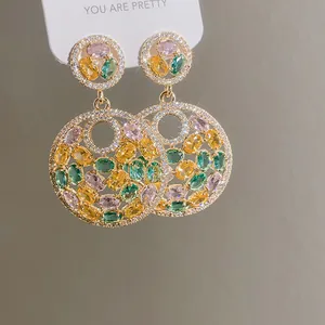 Detailed macro view of luxury gold earrings featuring colorful round zircon clusters