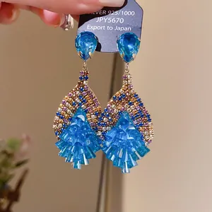 Detailed view of elegant teardrop tassel earrings with blue zircon stones.