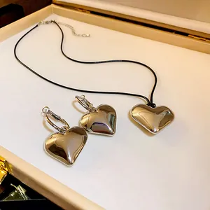 Dettaglio del set di gioielli minimalisti a cuore in argento con collana e orecchini